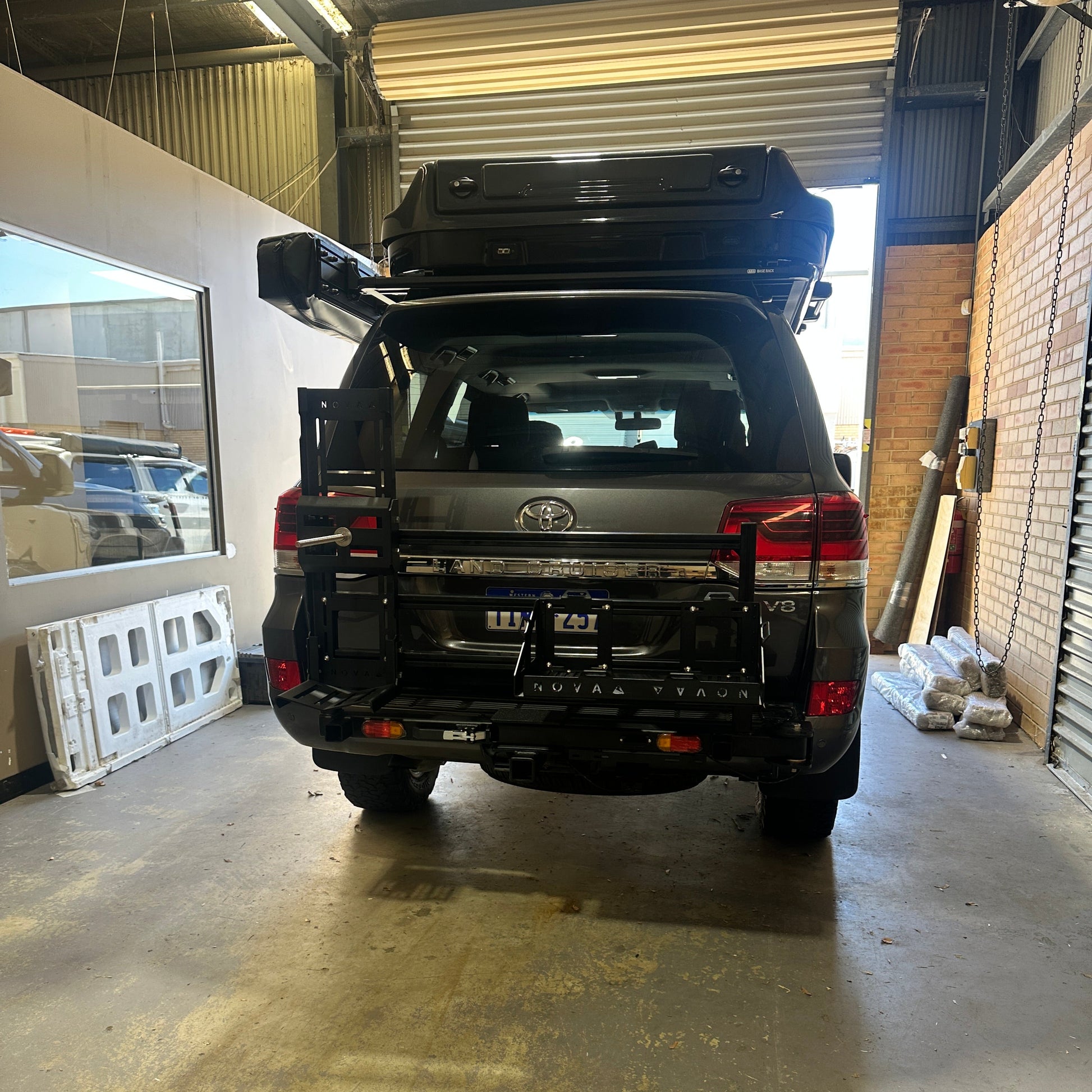 Black SUV parked inside a building with a concrete floor