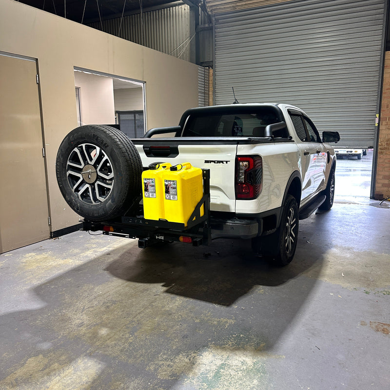 Small vehicle with a yellow toolbox attached, parked in a narrow alleyway.