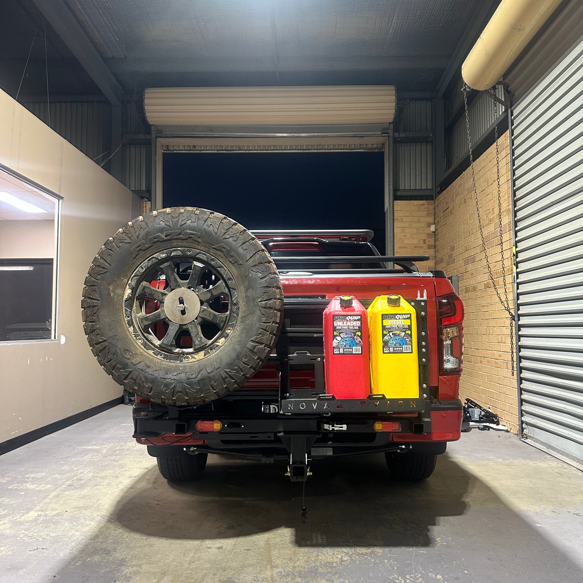 Red off-road vehicle with large tires in a narrow indoor space