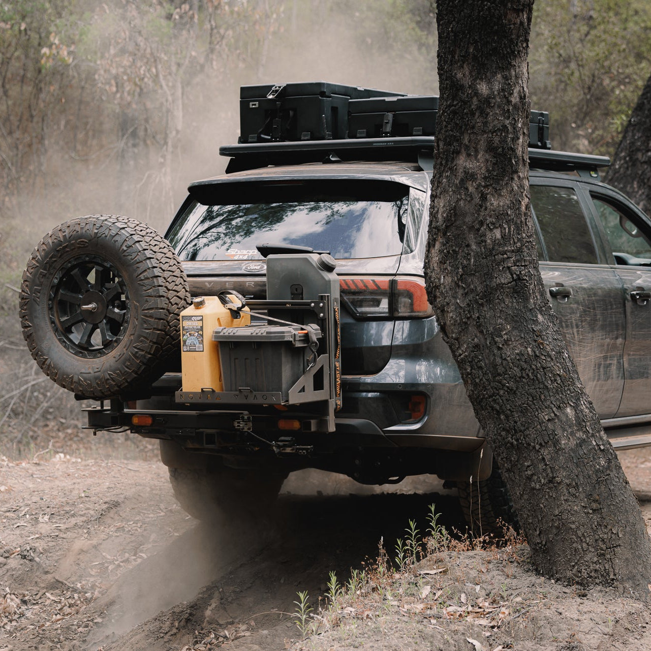 Off-road vehicle navigating a dirt path with trees and foliage in the background